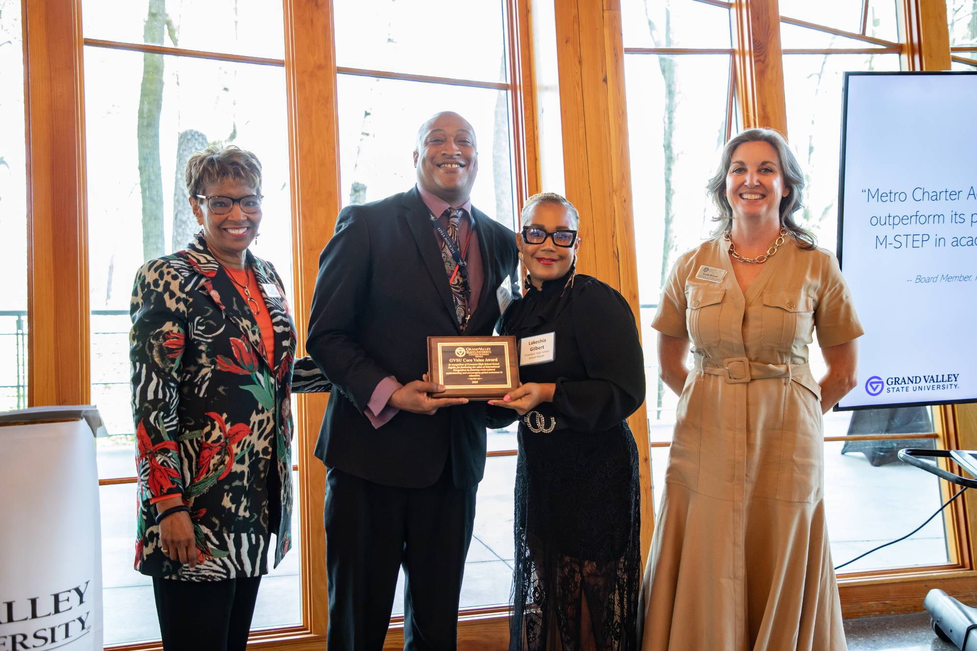 The school leader and board president of Covenant High School Grand Rapids pose with the 2025 Core Value Award alongside two members of the GVSU DEISS.